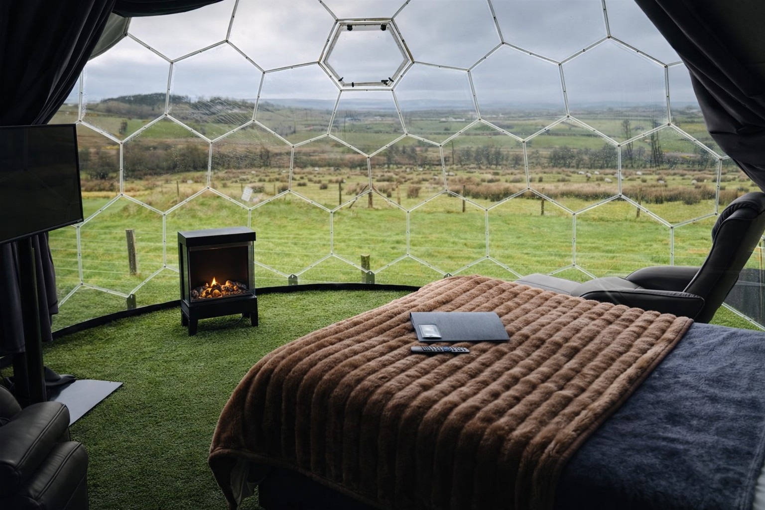 Bed inside The Atlantic dome with a fire and panoramic view